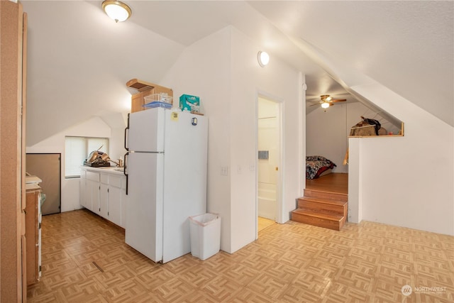 kitchen featuring light countertops, vaulted ceiling, freestanding refrigerator, and a ceiling fan