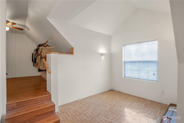 additional living space with parquet floors, a ceiling fan, and vaulted ceiling