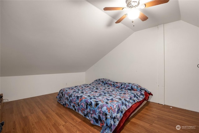 bedroom with wood finished floors, a ceiling fan, and vaulted ceiling