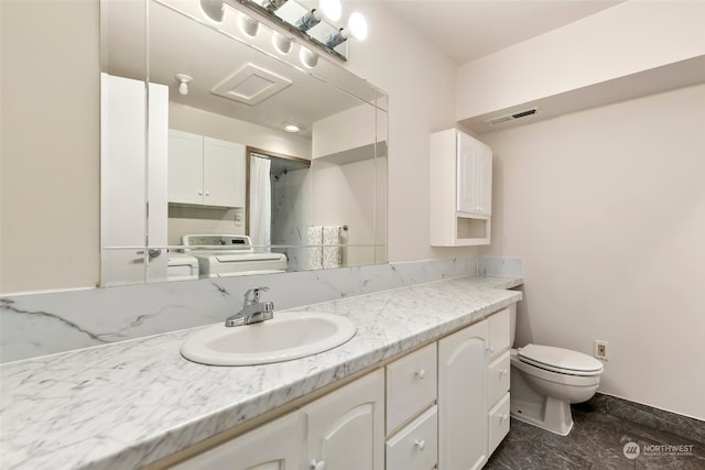 bathroom featuring vanity, toilet, and washer / dryer