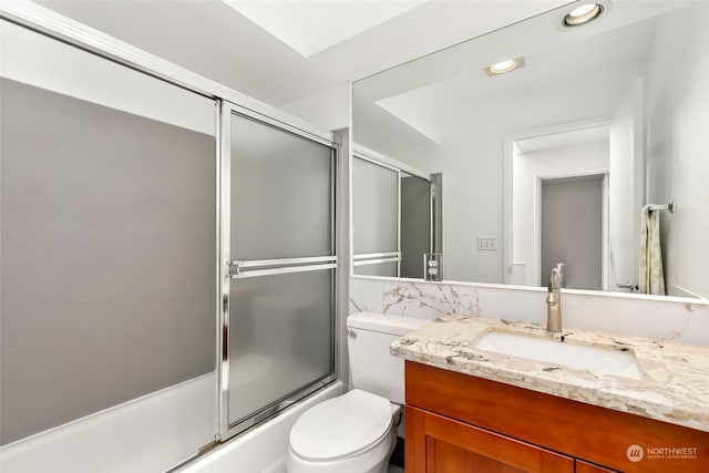 full bathroom with enclosed tub / shower combo, vanity, and toilet