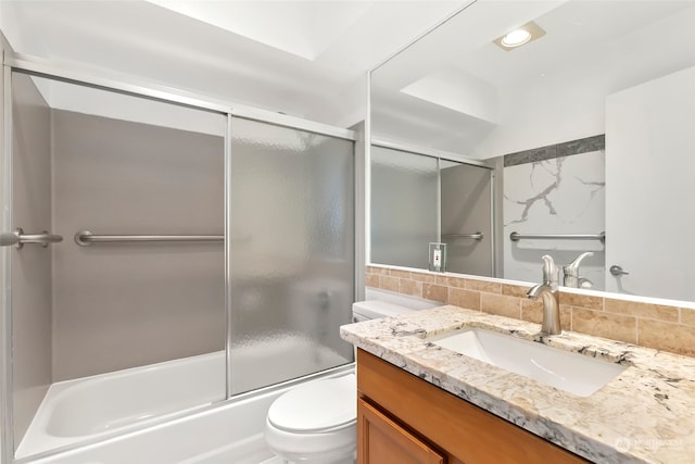 full bathroom featuring enclosed tub / shower combo, decorative backsplash, vanity, and toilet