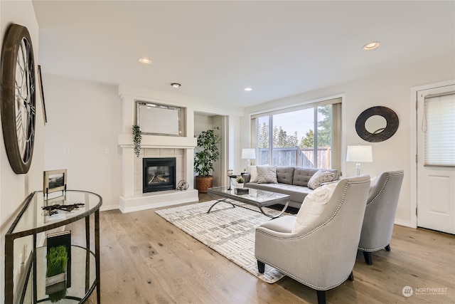 living room with light hardwood / wood-style flooring and a tiled fireplace