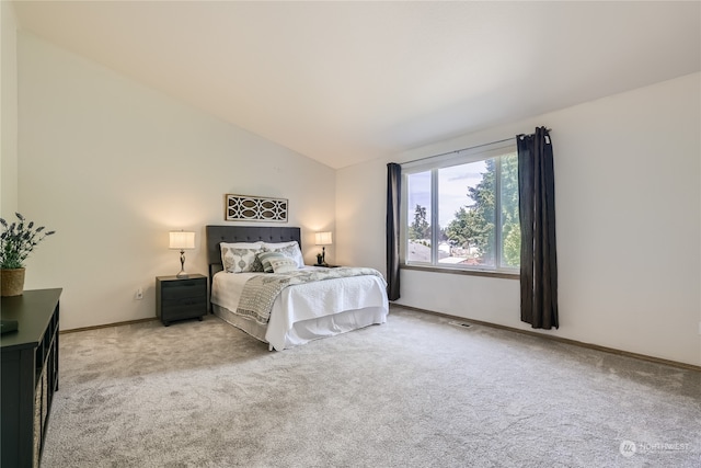 carpeted bedroom featuring lofted ceiling