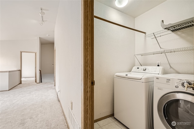 washroom with washer and clothes dryer and light colored carpet