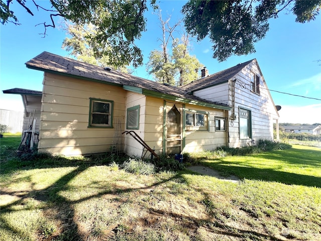 rear view of property with a lawn