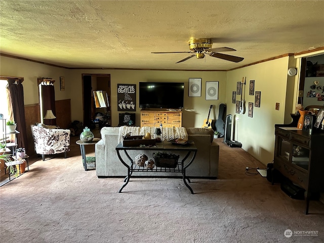 living room with a textured ceiling, crown molding, ceiling fan, and carpet floors