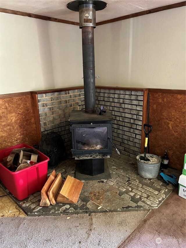 interior details with crown molding and a wood stove