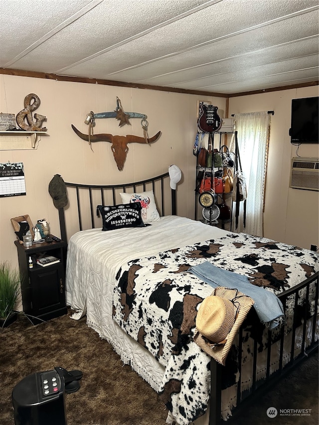 bedroom with a textured ceiling and dark carpet