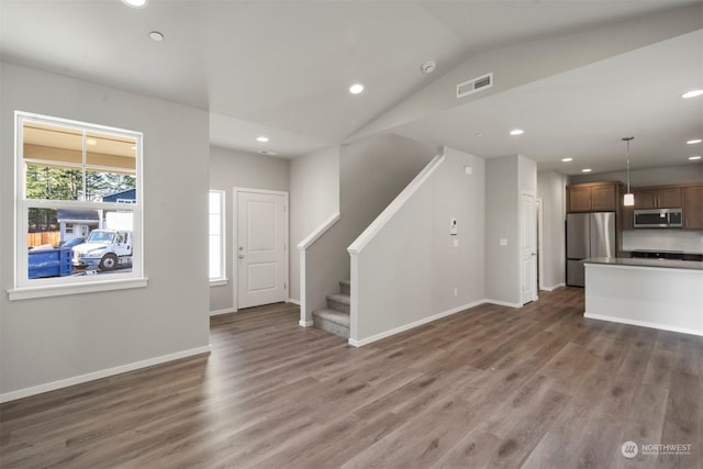 unfurnished living room featuring vaulted ceiling and dark hardwood / wood-style flooring