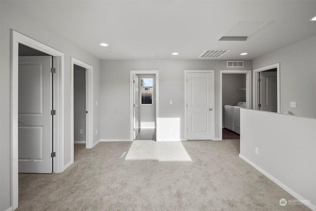 carpeted spare room featuring independent washer and dryer