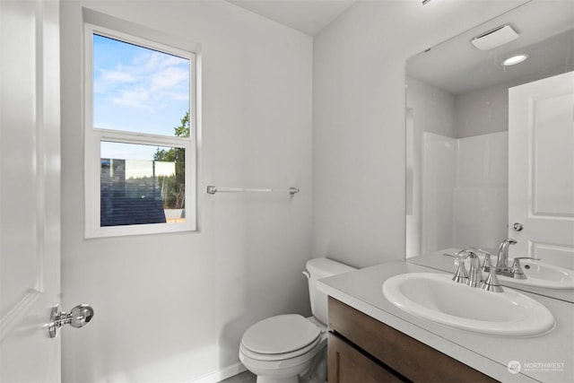 bathroom featuring walk in shower, vanity, and toilet