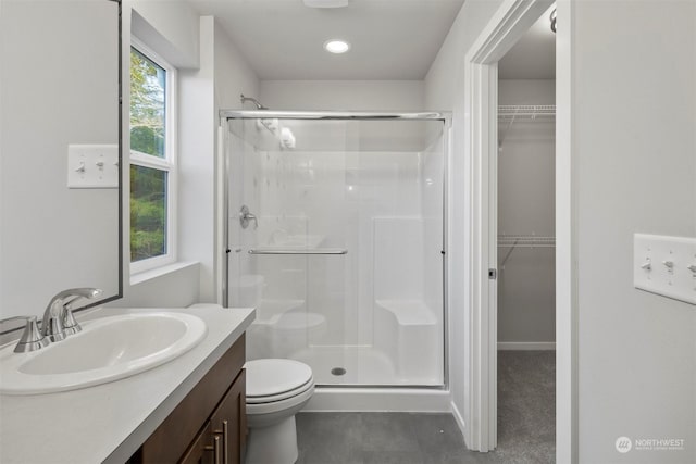 bathroom with vanity, toilet, and a shower with shower door