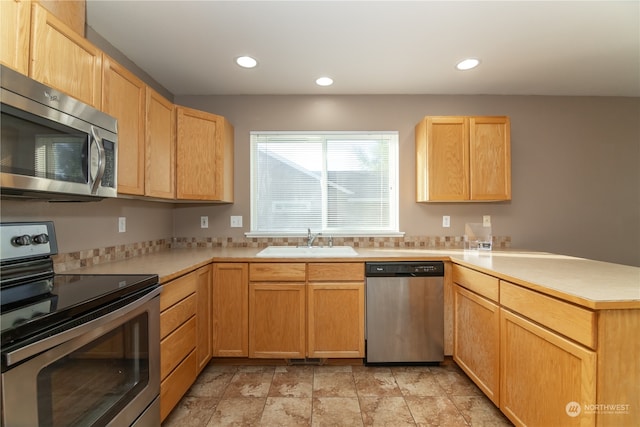 kitchen featuring light brown cabinetry, kitchen peninsula, sink, and stainless steel appliances