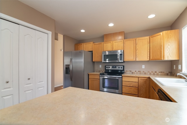 kitchen with light brown cabinets, sink, and stainless steel appliances