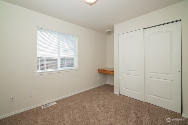 unfurnished bedroom with carpet and a closet