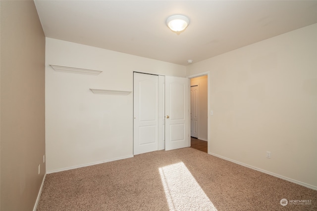 unfurnished bedroom with a closet and carpet flooring