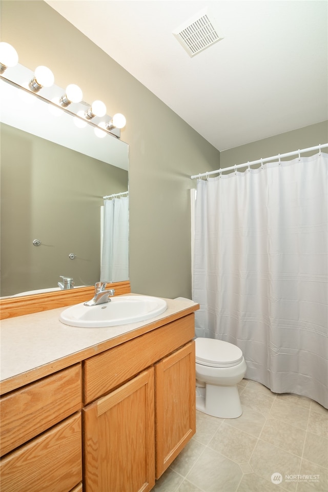 bathroom featuring tile patterned flooring, vanity, and toilet