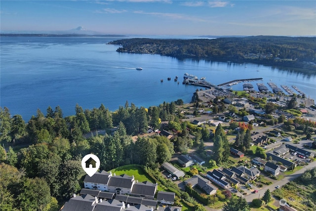 drone / aerial view featuring a water view and a wooded view