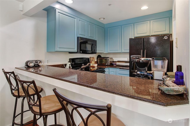 kitchen with recessed lighting, a peninsula, black appliances, and blue cabinetry