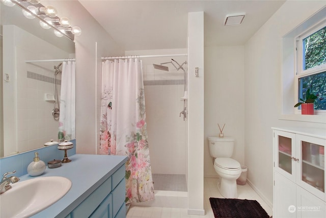 full bathroom with toilet, a tile shower, tile patterned flooring, and vanity