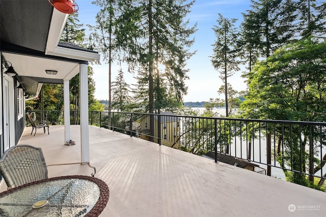 view of patio with a water view and a balcony