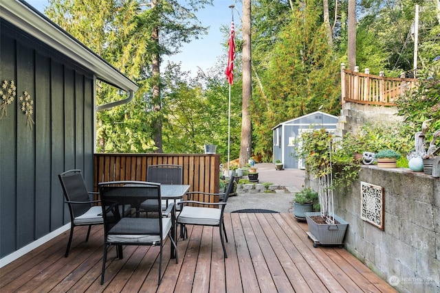 291 E Midway Ln, Shelton, WA 98584 - wooden deck featuring a storage unit, outdoor dining space, and an outbuilding