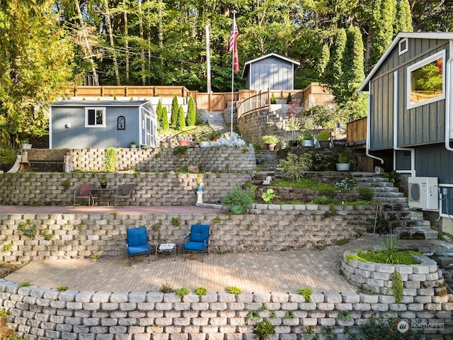 view of yard with ac unit, a storage unit, and a patio area