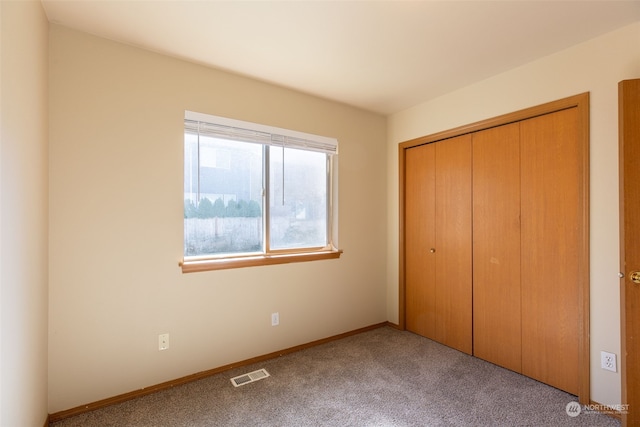 unfurnished bedroom featuring a closet and light carpet