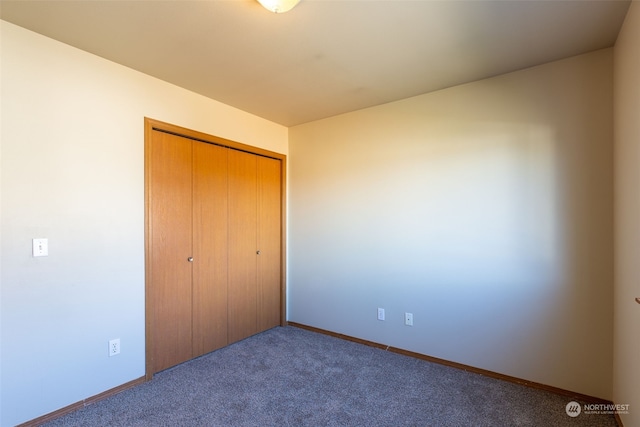 unfurnished bedroom with a closet and carpet flooring