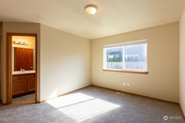 unfurnished room featuring sink and dark carpet