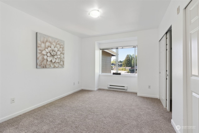 spare room featuring light carpet and baseboard heating