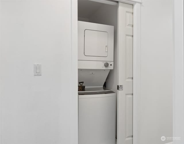 clothes washing area with stacked washer and clothes dryer