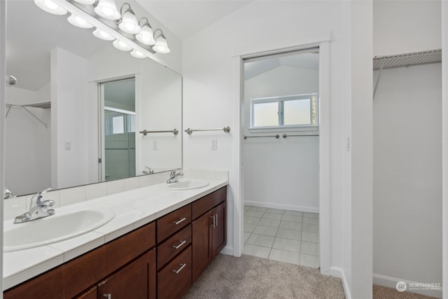 bathroom featuring vanity, tile patterned floors, and lofted ceiling