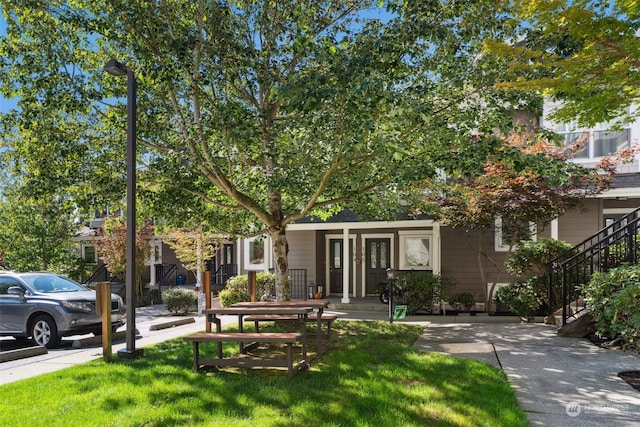 view of property hidden behind natural elements with a front yard