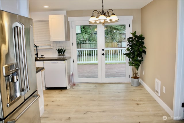 entryway featuring sink, french doors, light hardwood / wood-style flooring, and an inviting chandelier