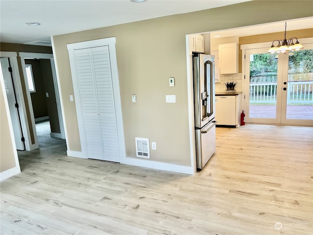 kitchen featuring dishwasher, hanging light fixtures, tasteful backsplash, stainless steel fridge, and light hardwood / wood-style floors