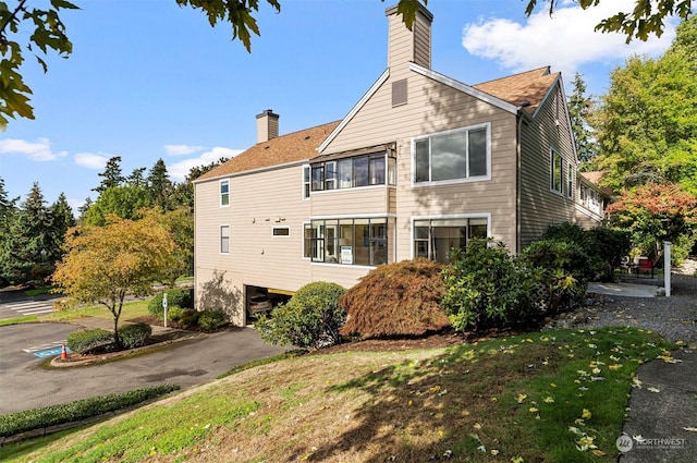 4152 Providence Point Dr SE Unit 207, Issaquah, WA 98029 - view of property exterior featuring a chimney, asphalt driveway, and an attached garage