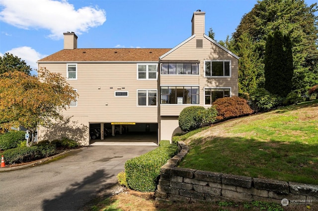 4152 Providence Point Dr SE Unit 207, Issaquah, WA 98029 - back of property featuring a carport, driveway, a yard, and a chimney