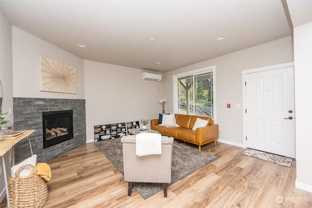 living room with hardwood / wood-style floors, a stone fireplace, and an AC wall unit