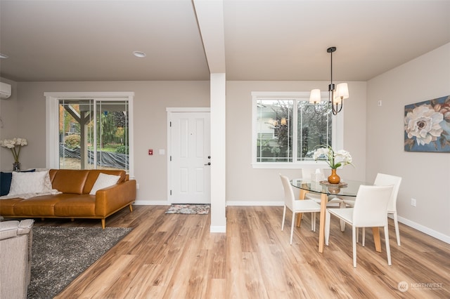 dining area featuring a wall unit AC, an inviting chandelier, and hardwood / wood-style flooring