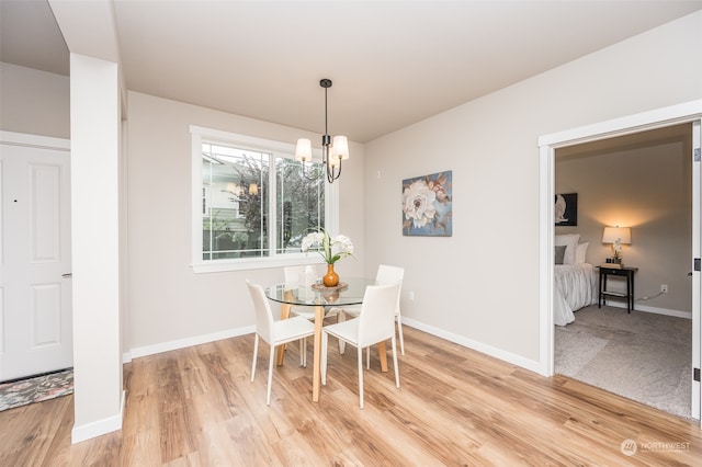 dining area featuring wood-type flooring and a notable chandelier