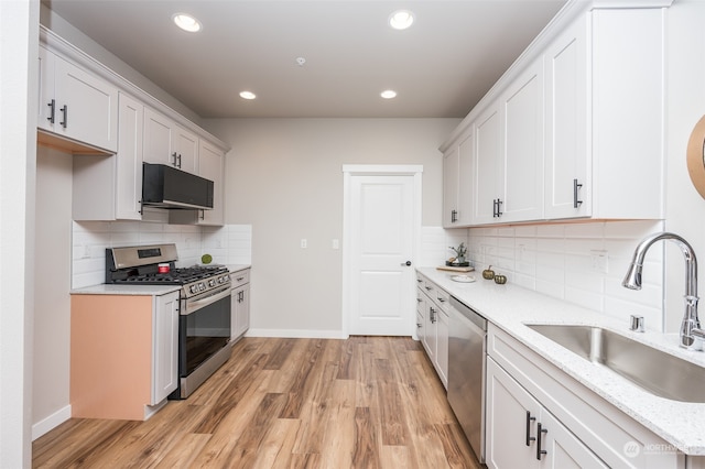 kitchen featuring sink, white cabinets, light wood-type flooring, and appliances with stainless steel finishes