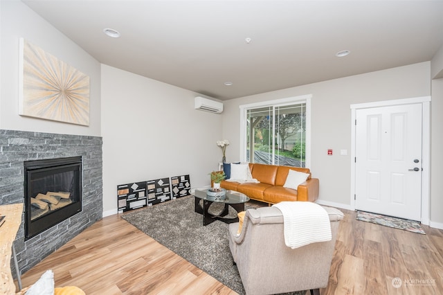 living room featuring a wall mounted air conditioner, a fireplace, and hardwood / wood-style flooring