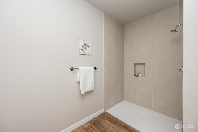 bathroom with hardwood / wood-style floors and a tile shower