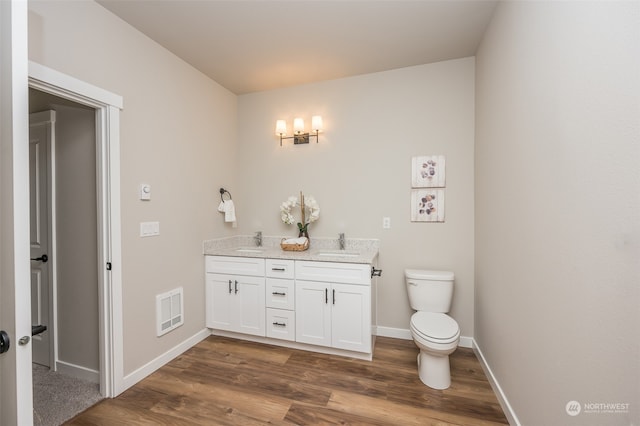 bathroom with hardwood / wood-style floors, vanity, and toilet