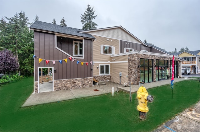 back of house featuring a lawn and a patio area