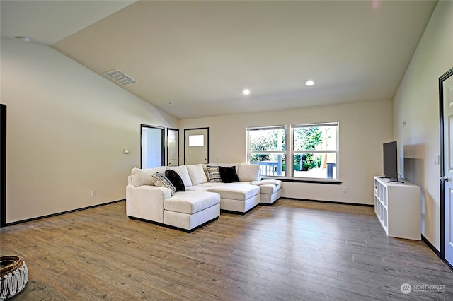 living room with light wood-type flooring and vaulted ceiling