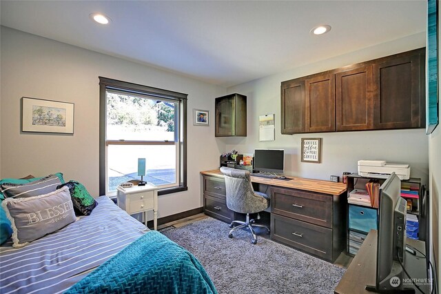 bedroom with light wood-type flooring and built in desk