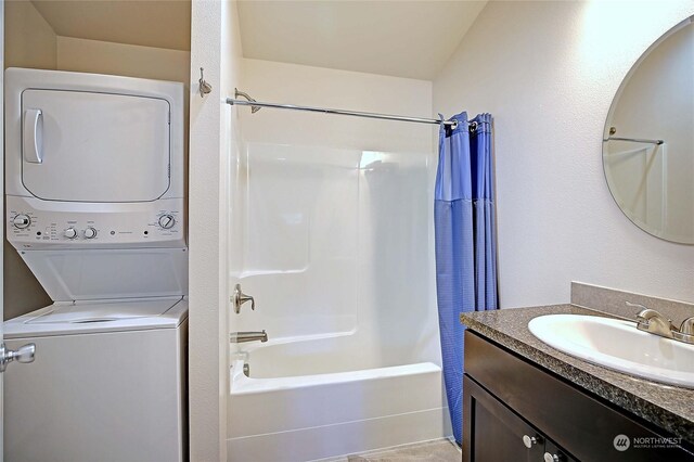 bathroom featuring vaulted ceiling, vanity, stacked washer / drying machine, and shower / bath combo